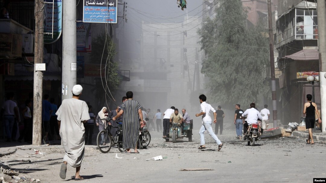 Cư dân bỏ chạy vì pháo kích trên đường phố ở thị trấn Aleppo của thành phố al-Shaar, ngày 16/9/2012