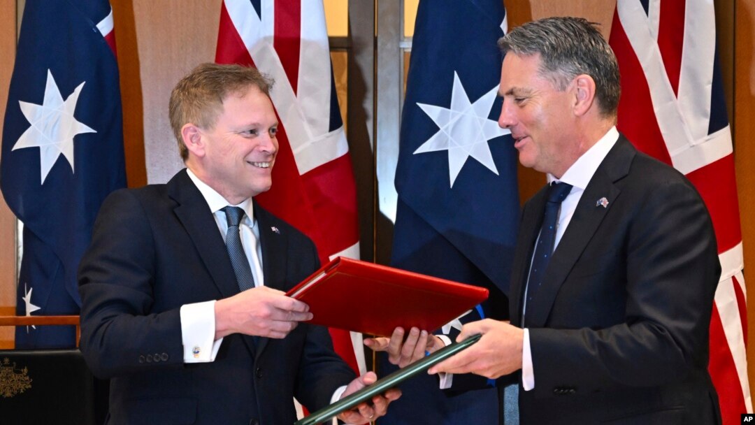 Bộ trưởng Quốc phòng Anh Grant Shapps (trái) và Bộ trưởng Quốc phòng Úc Richard Marles trao đổi thỏa thuận hợp tác quốc phòng và an ninh mới tại Canberra, vào ngày 21/3/2024.