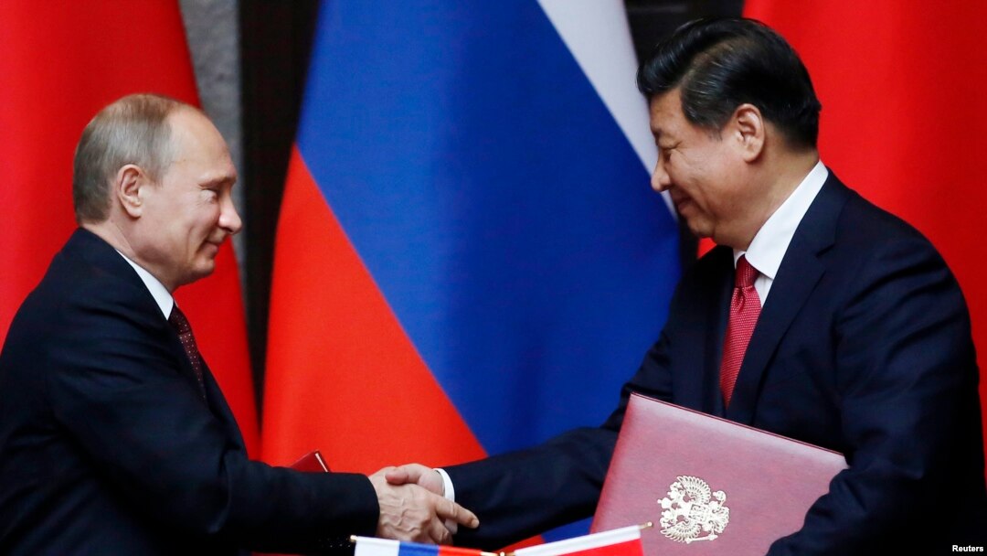 Tổng thống Nga Vladimir Putin (trái) và Chủ tịch Trung Quốc Tập Cận Bình bắt tay sau khi ký kết một thỏa thuận 20/5/14
