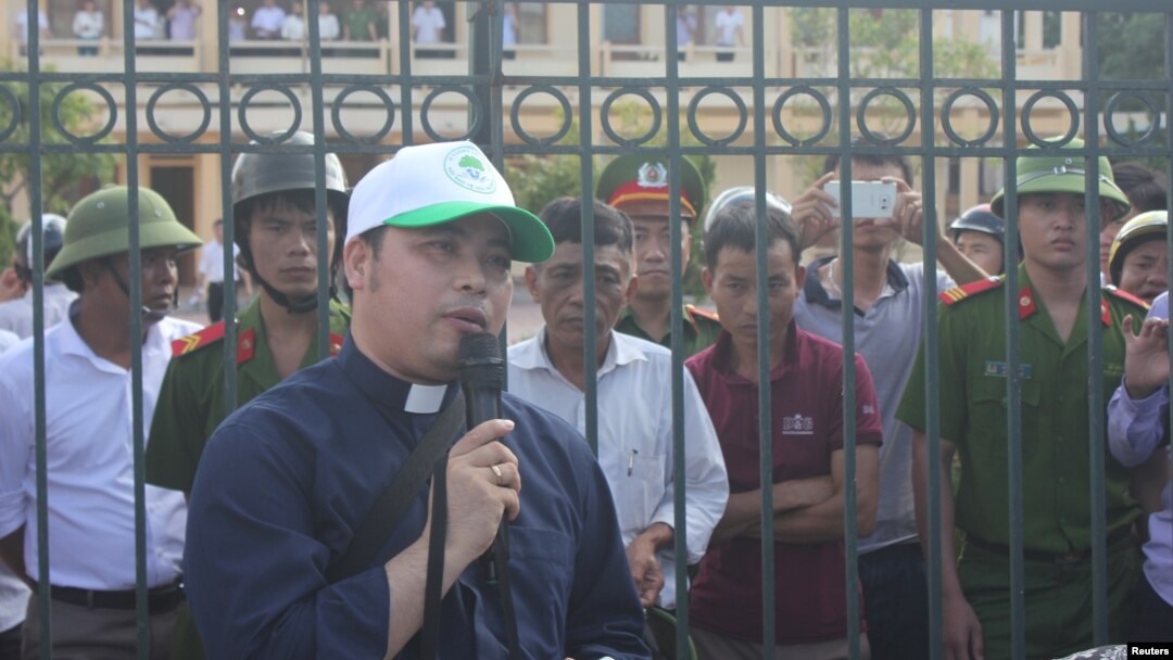 Linh mục Đặng Hữu Nam nói chuyện với ngư dân chờ đợi bên ngoài trụ sở Tòa án Nhân dân Thị xã Kỳ Anh, Hà Tĩnh, 26/9/2016.