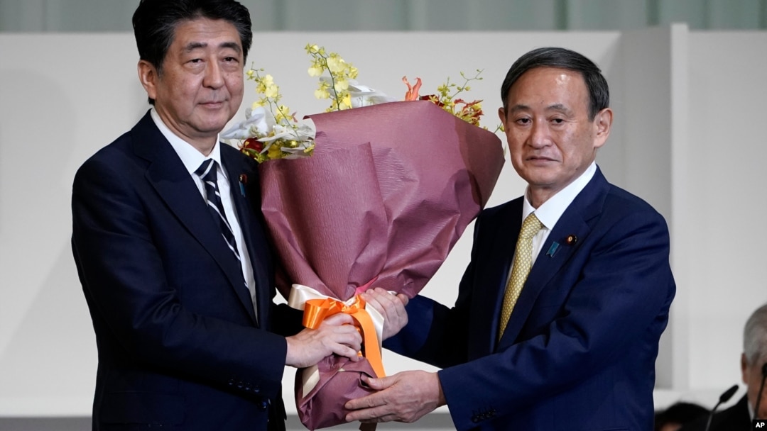 Ông Yoshihide Suga (phải) và người tiền nhiệm Shinzo Abe. 