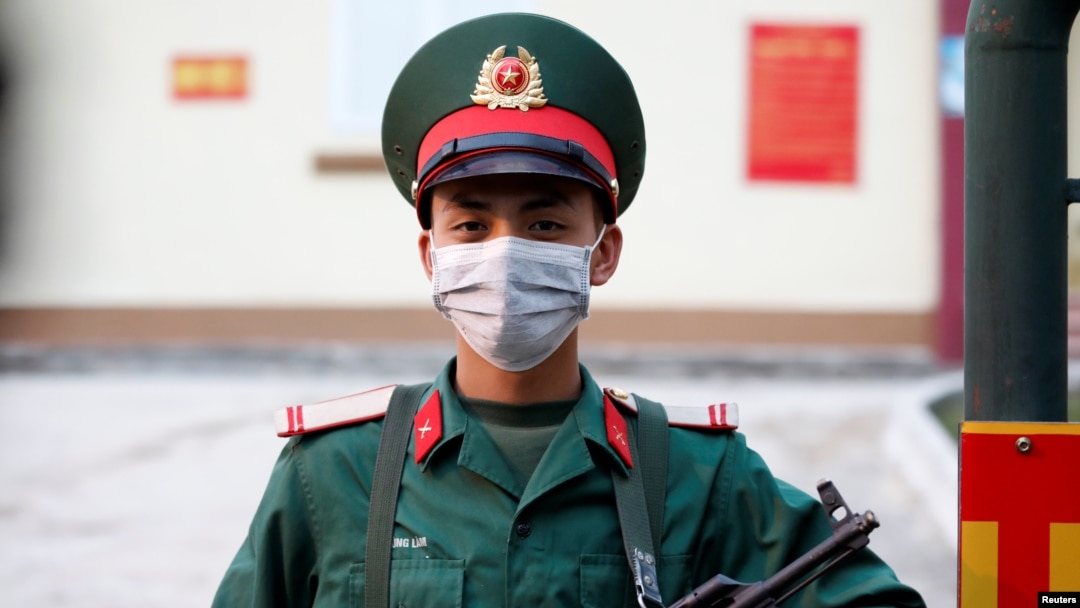 Một người lính Việt Nam đứng gác bên ngoài khu cách ly của một doanh trại quân đội ở tỉnh Lạng Sơn. Hàng chục nghìn người đang bị cách ly trong lúc làn sóng người Việt trở về từ nước ngoài giữa dịch bệnh Covid-19.