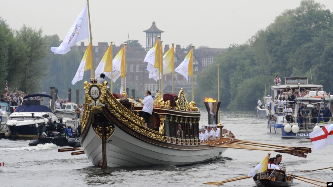 Ngọn đuốc Olympic đang được rước dọc theo sông Thames trên chiếc thuyền Gloriana của hoàng gia